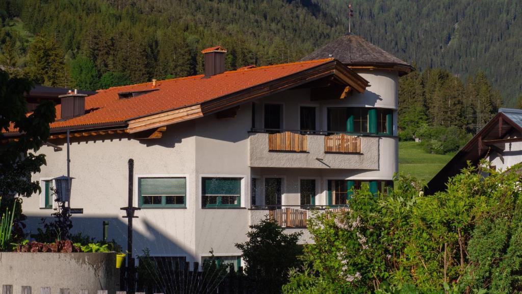 une maison blanche avec un toit orange dans l'établissement Appartement Strolz, à Schnann