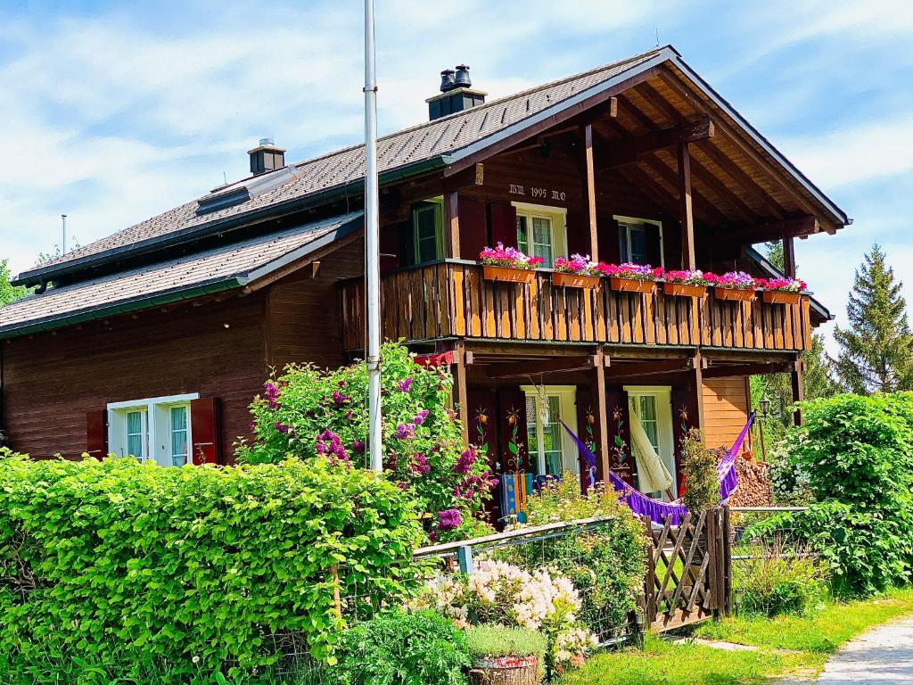 uma casa de madeira com caixas de flores na varanda em The Swiss Paradise 1 Penthouse apartment em Wirzweli