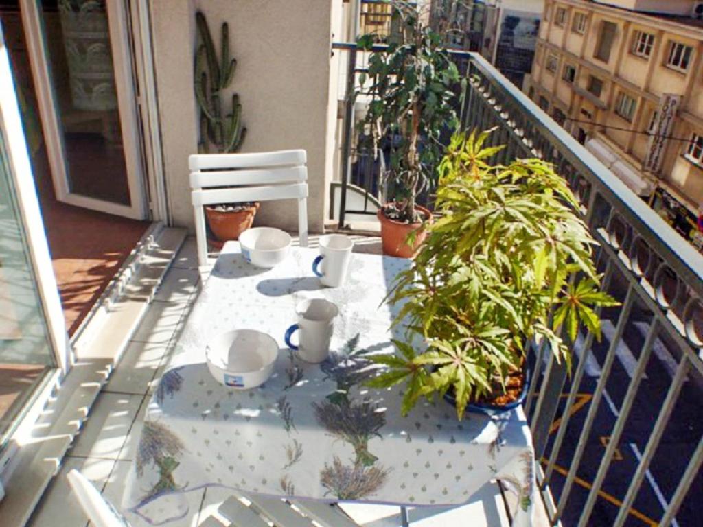 un balcón con una mesa con plantas. en Appartement d'une chambre a Cannes a 300 m de la plage avec vue sur la ville balcon et wifi en Cannes