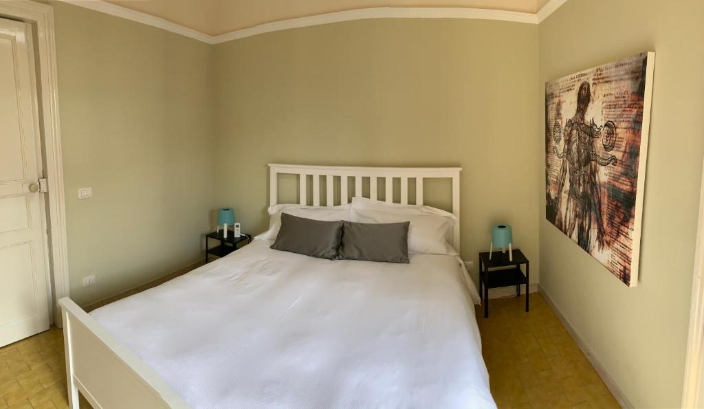a bedroom with a large white bed with two night stands at Corte dei medici - Palace in Catania