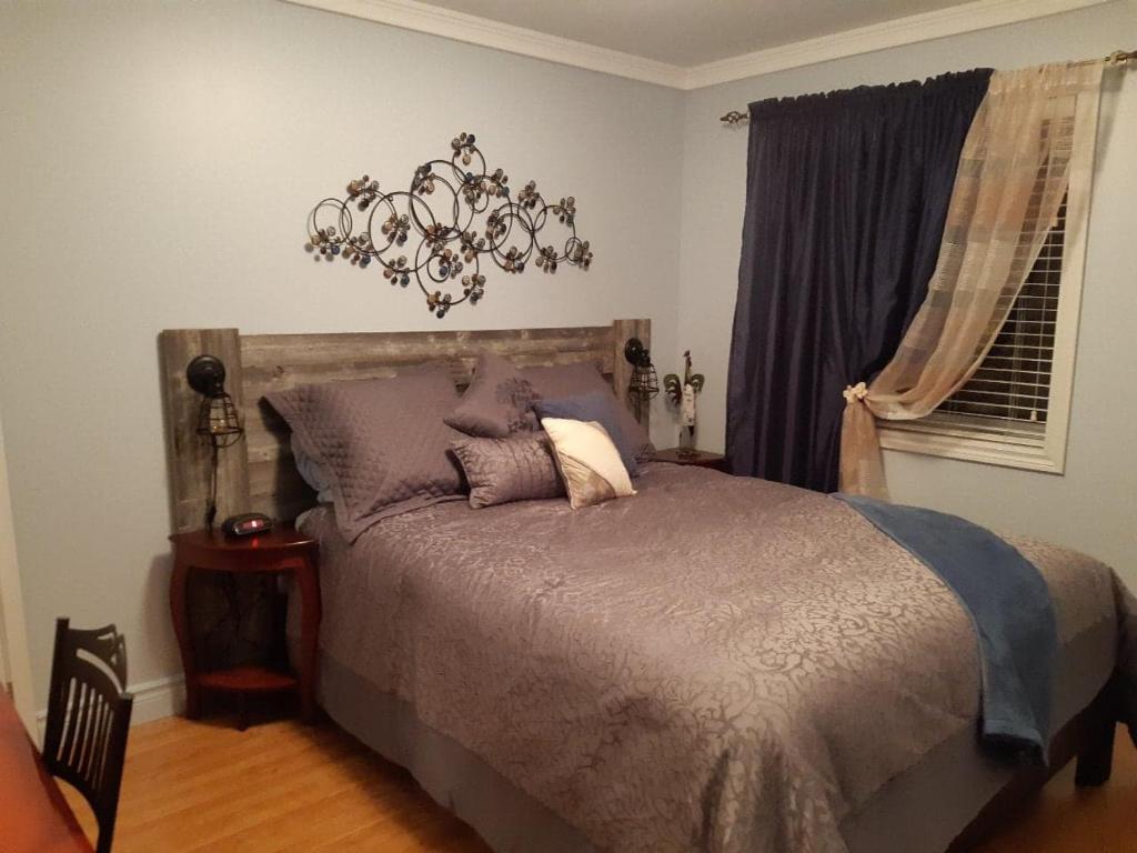 a bedroom with a bed and a chandelier at Les Gites Makadan in Normandin