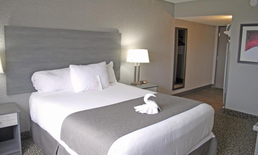 a hotel room with a bed with a white duck on it at Ramada by Wyndham Edmonton Yellowhead NW in Edmonton