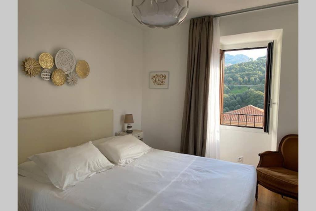 a bedroom with a white bed and a window at FUNTANA NOVA in Piana