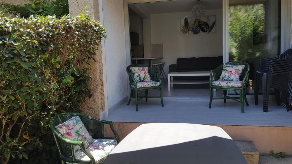 a porch with chairs and a table and a couch at COLLIOURE tres bel appart a 150 metres des plages avec jardin prive et parking dans residence securisee in Collioure