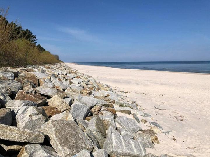 a large pile of rocks on a sandy beach at Morskie Zacisze Karwia in Karwia