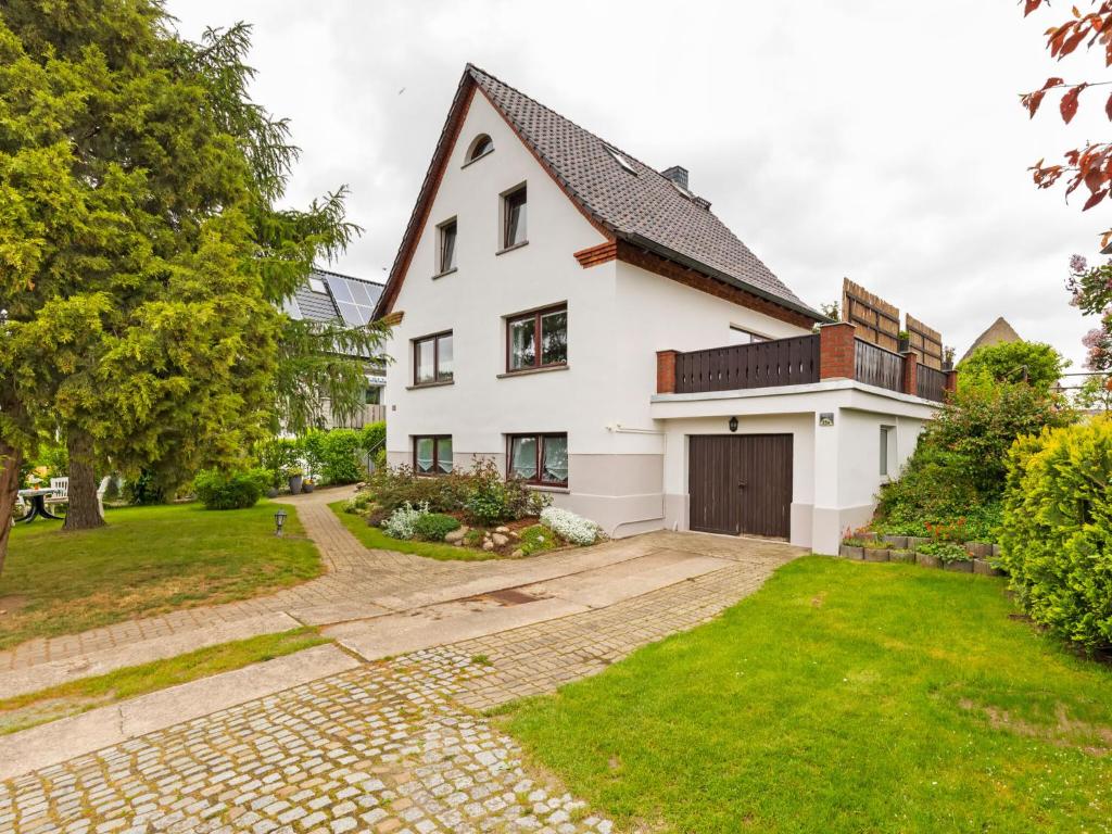 eine Außenansicht eines weißen Hauses mit Auffahrt in der Unterkunft Comfortable Apartment in Wismar near the Baltic Sea in Wismar