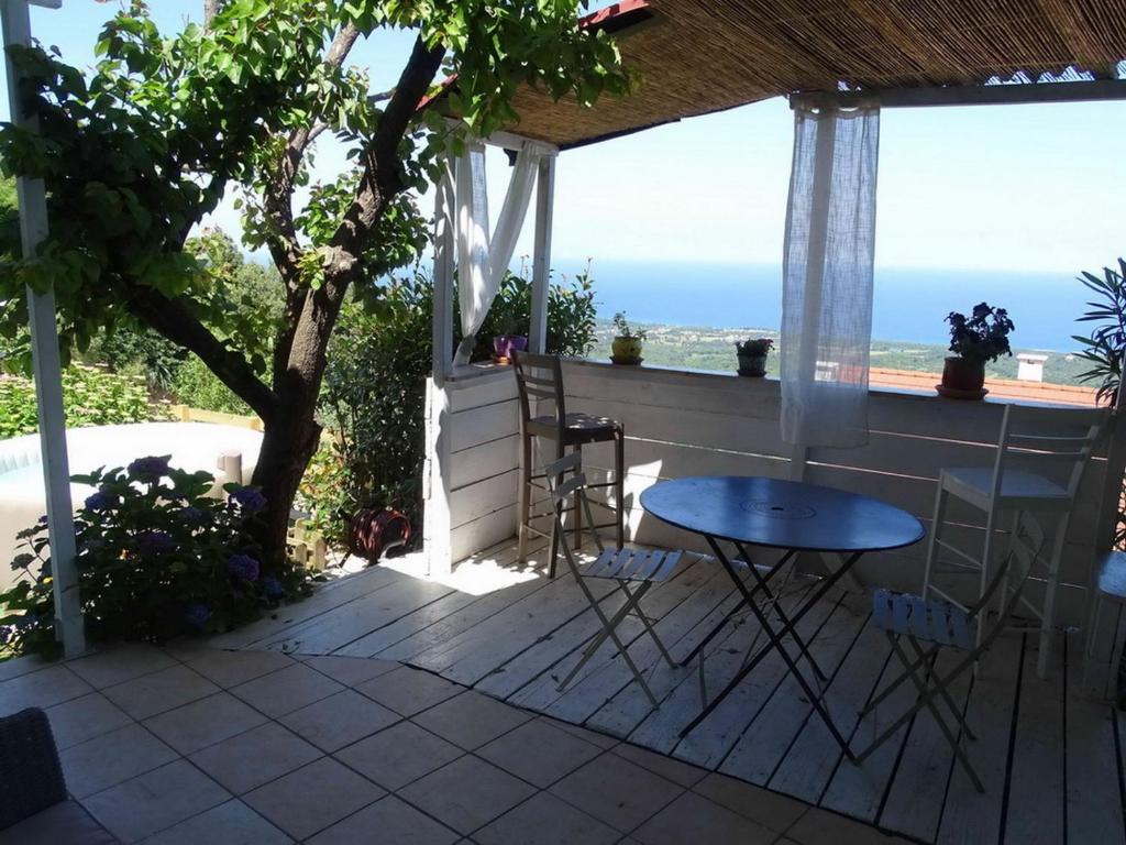 een patio met een tafel en stoelen en uitzicht op de oceaan bij CASA PENTONE in Cervione