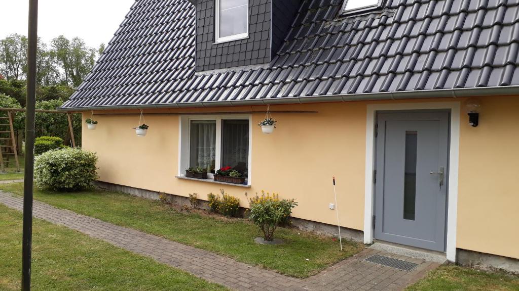 una casa con techo negro y puerta gris en Ferienhaus Monika, en Mursewiek