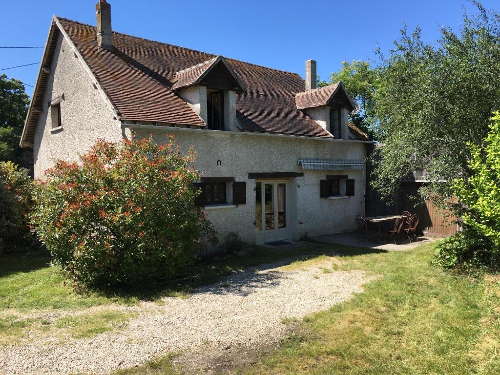 una vieja casa blanca con una mesa delante en Maison Coeur de Brenne en Rosnay