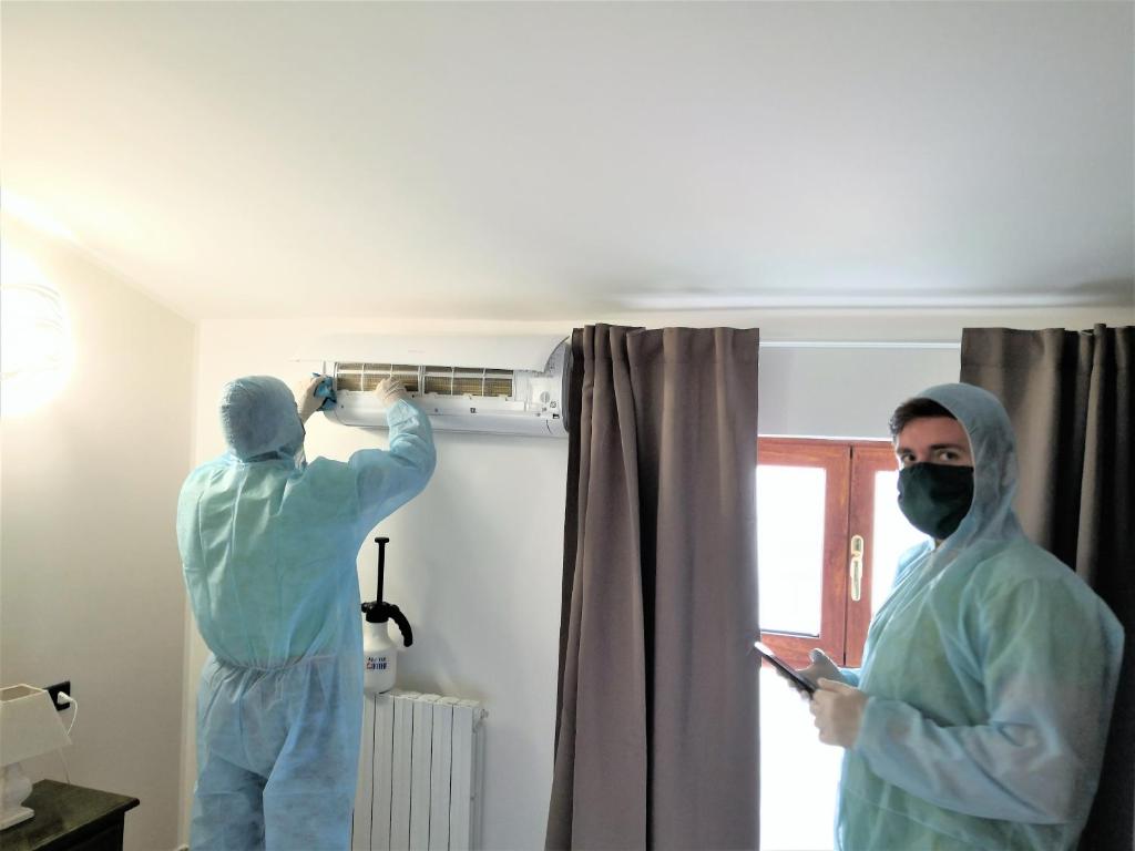 two people in scrubs are painting a room at Plaza Rooms Ciampino in Ciampino
