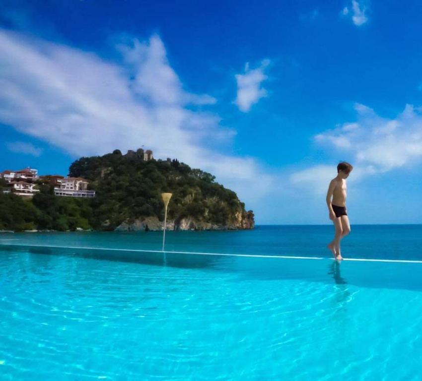 człowiek stojący na krawędzi basenu w oceanie w obiekcie Ionion Beach Resort w mieście Parga