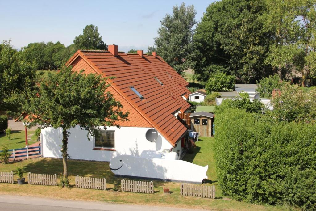 a small white house with an orange roof at GoWatt in Friedrichskoog