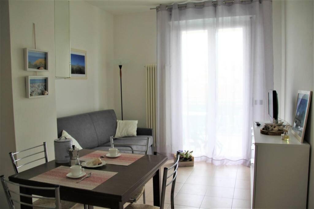 een woonkamer met een tafel en een bank bij Appartamento delle Vele in Bellaria-Igea Marina
