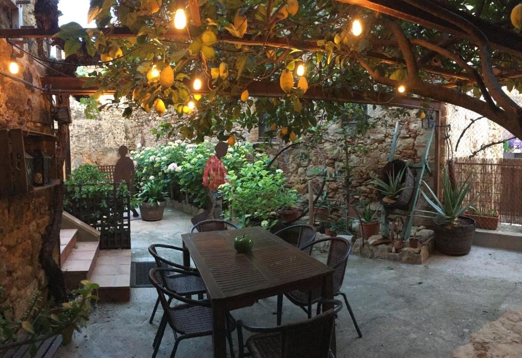 a patio with a table and chairs under a pergola at Can Zoilo Pals in Pals