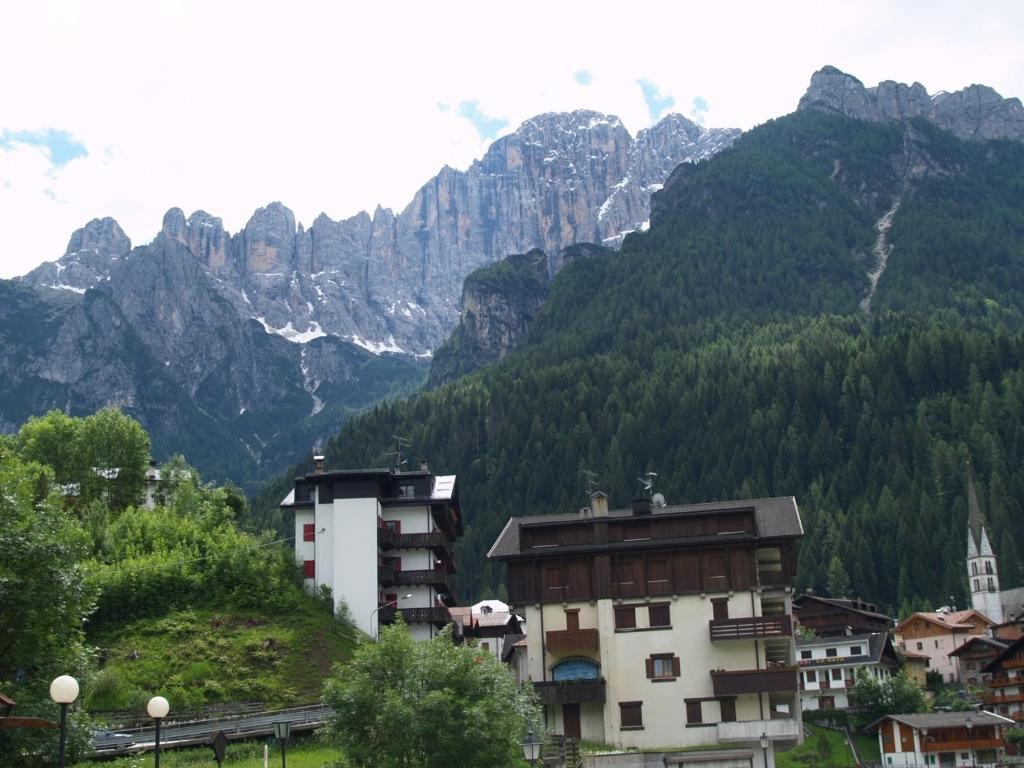 a town in front of a mountain with trees and buildings at Appartamenti Katinanna in Alleghe