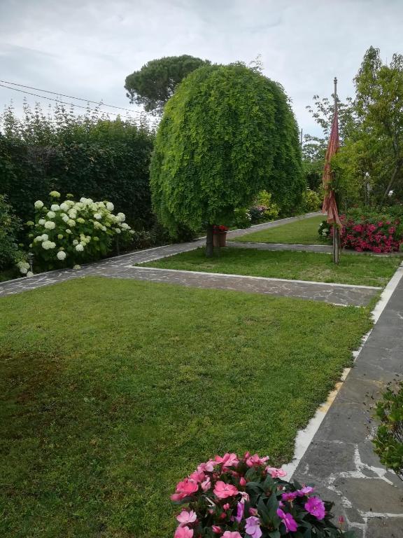 a garden with pink flowers and a tree at Casa Pianta in Cavallino-Treporti