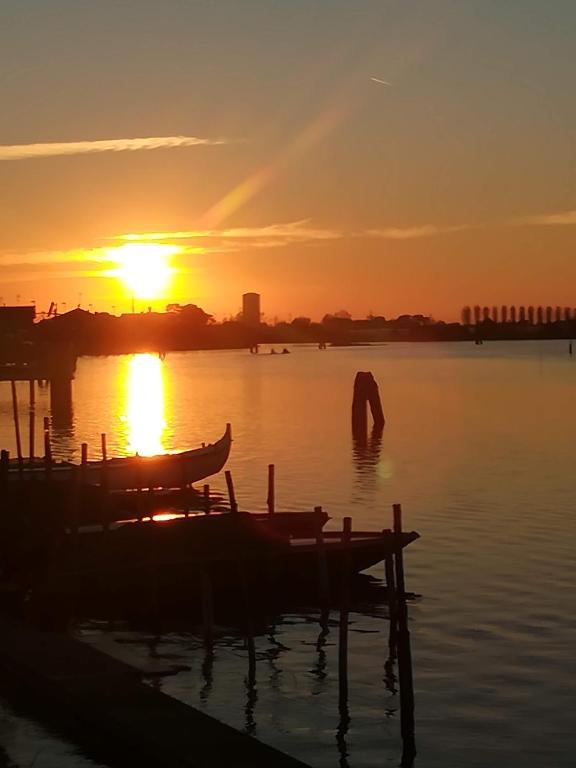 a sunset over a body of water with a boat at Casa Pianta in Cavallino-Treporti