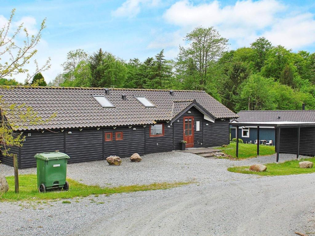 une maison noire avec une allée en gravier devant elle dans l'établissement 8 person holiday home in Aabenraa, à Loddenhøj