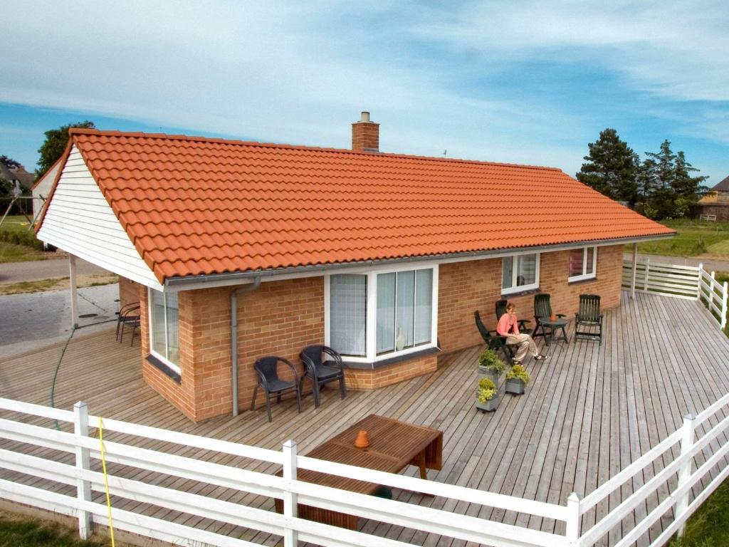 HumbleにあるHoliday Home Toften IVの木製デッキ上のオレンジ色の屋根の家