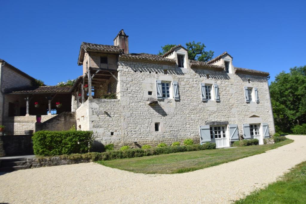 une ancienne maison en pierre avec un chemin en face de celle-ci dans l'établissement Les Terrasses de La Serre, à Lascabanes