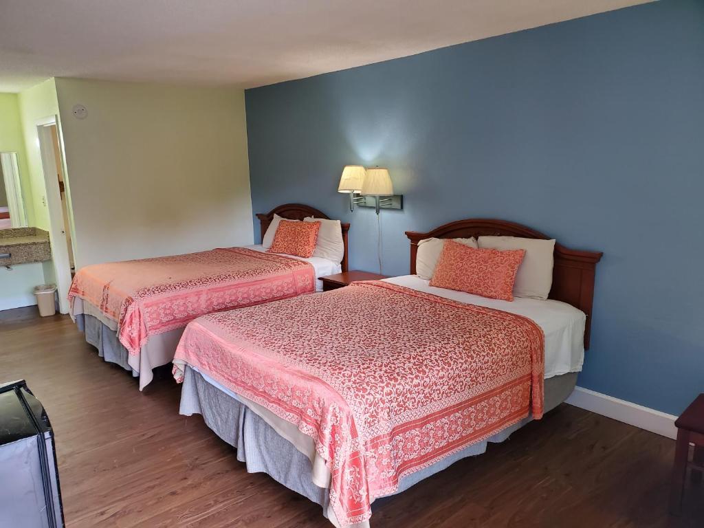 a hotel room with two beds with red and white sheets at Econo Inn - Ormond Beach in Ormond Beach