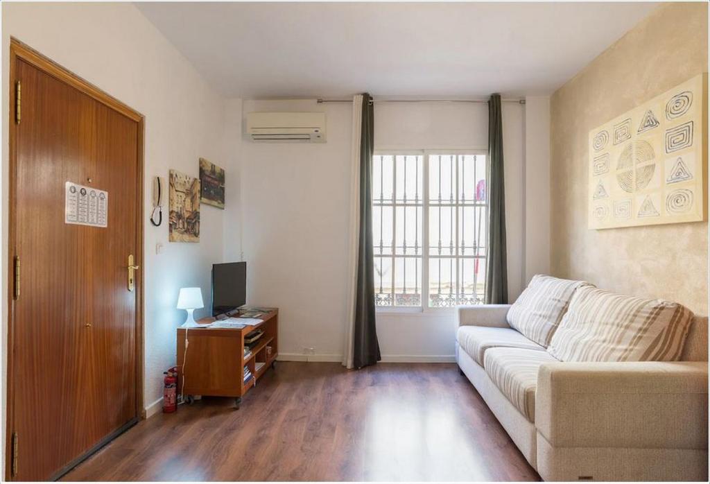 a living room with a couch and a window at Perla Lagunillas Málaga in Málaga