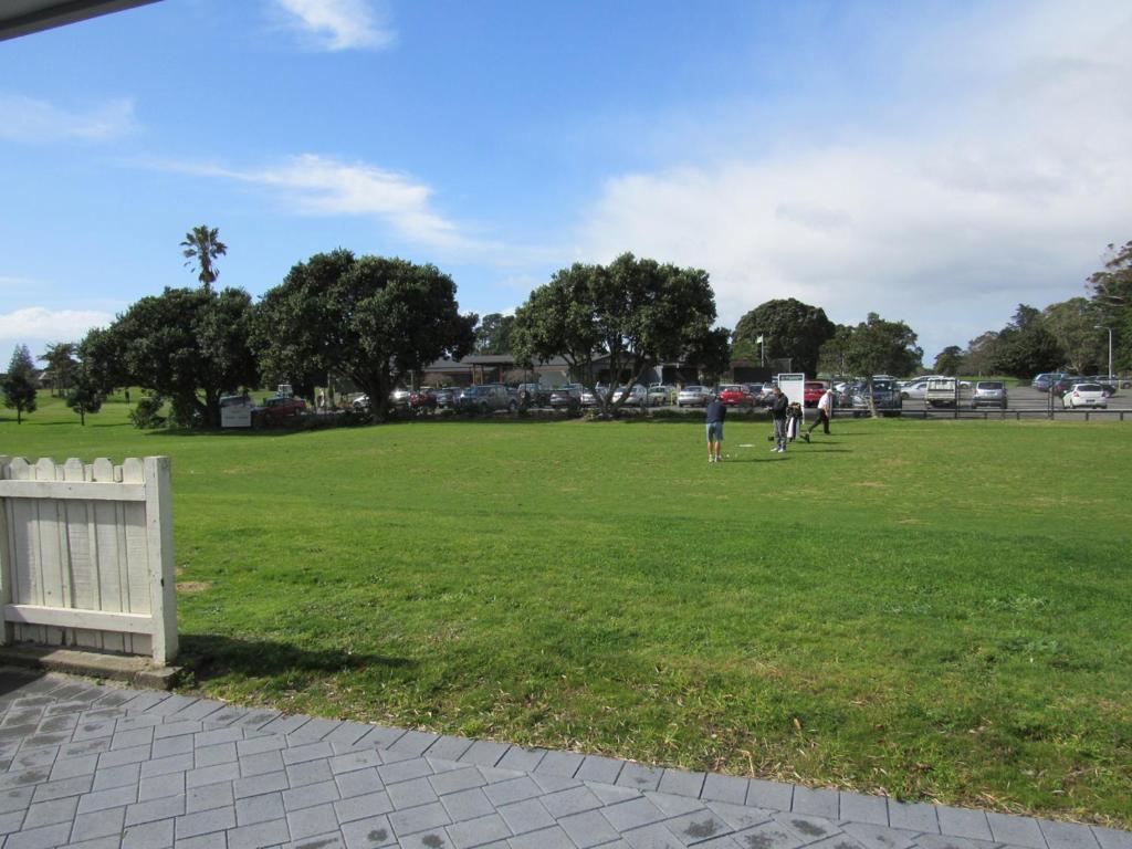 un parco con persone che camminano nell'erba di The Practice Fairway a Tauranga