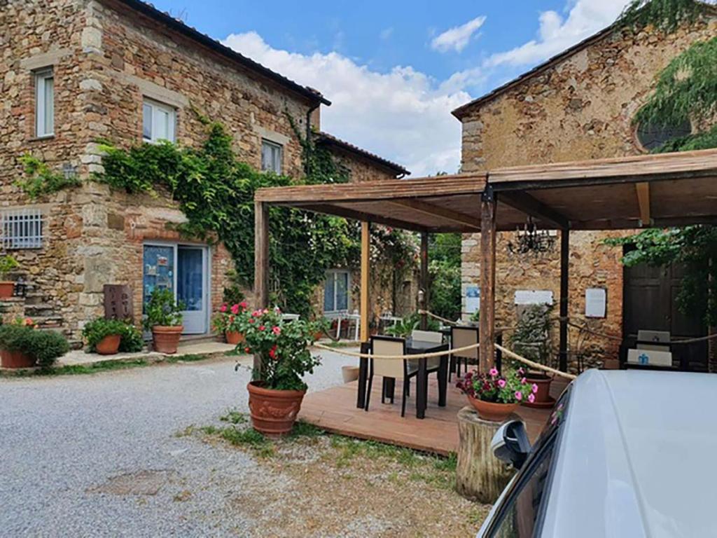 un patio de madera con una mesa y un edificio en Bed And Breakfast Belvedere, en Suvereto