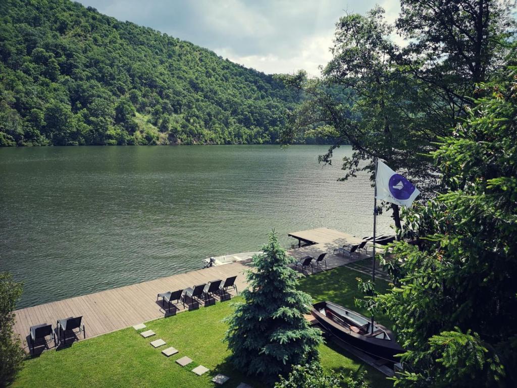 vistas a un lago con sillas y una bandera en Nautica Bahna en Orşova