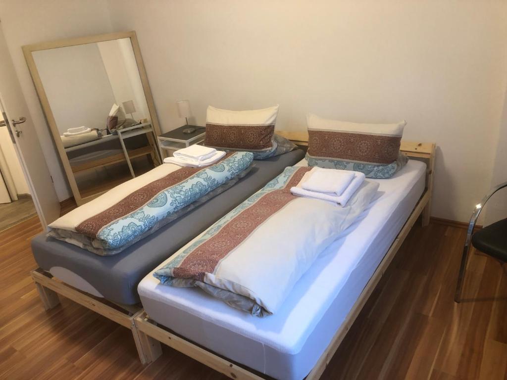 Duas camas individuais num quarto com um espelho. em Bosskopp em Alzenau in Unterfranken