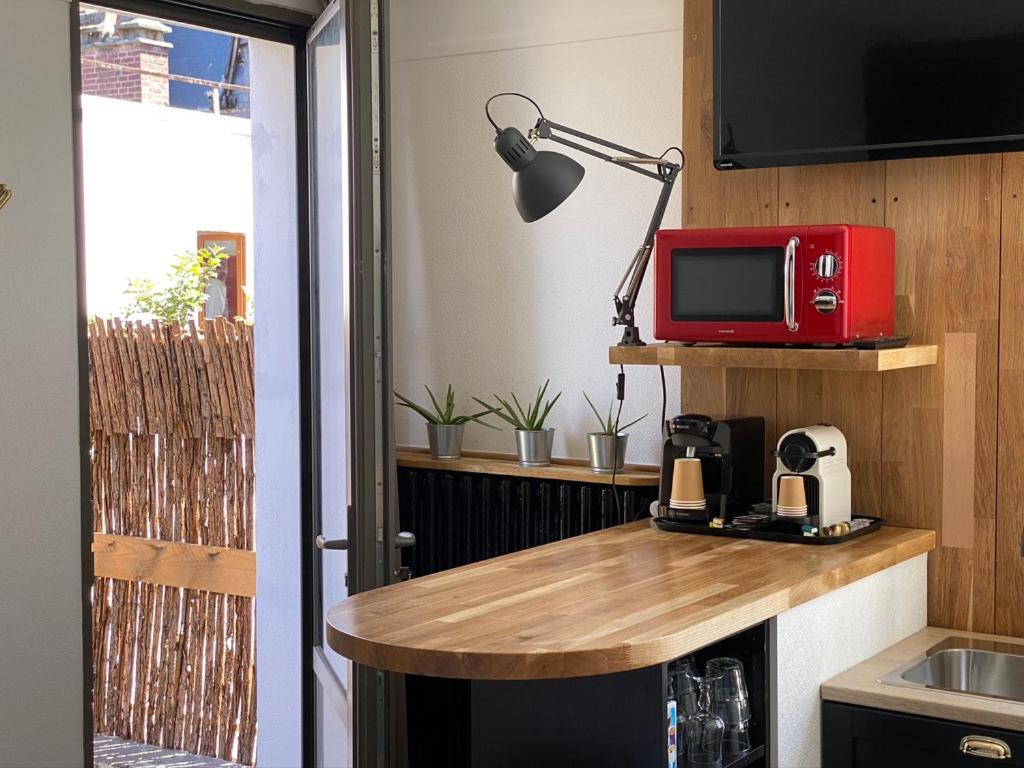 a kitchen with a counter with a red microwave at Hôtel De La Cathédrale in Rouen