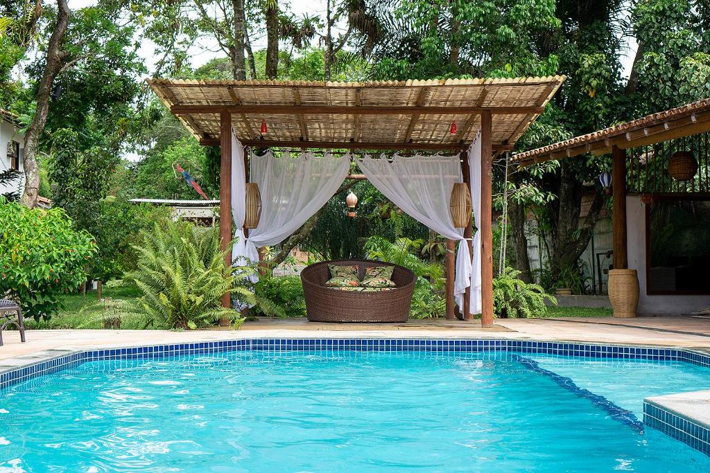 uma piscina com um gazebo ao lado em Trancoso Pousada em Trancoso