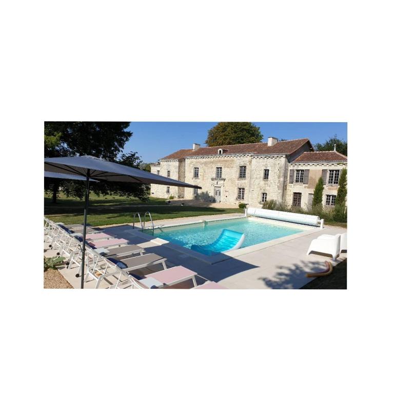 une piscine avec des chaises et un parasol ainsi qu'une maison dans l'établissement Domaine de Bourgville, à Monts-sur-Guesnes