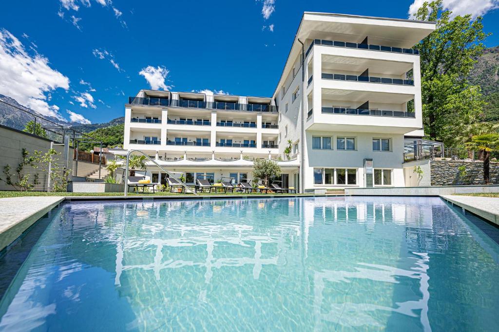 a large swimming pool in front of a building at Das Mitterplarser Hotel in Lagundo