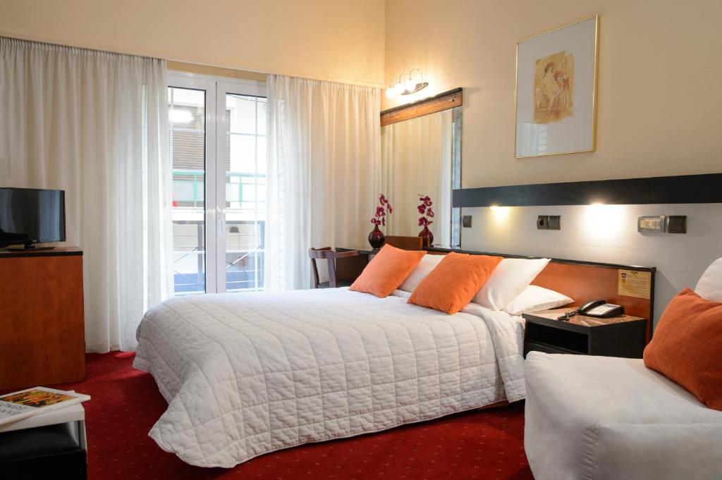 Habitación de hotel con cama y sofá en Victory Inn, en Atenas