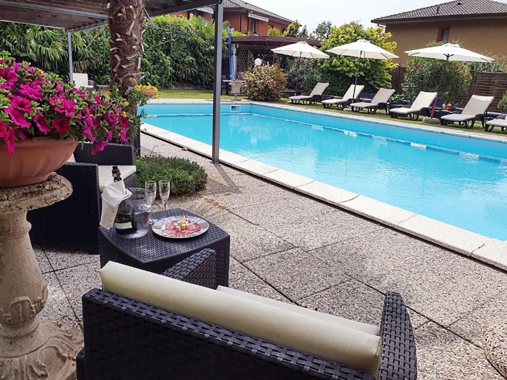 einen Pool mit einem Stuhl und einem Tisch in der Unterkunft Apartment Lake Maggiore - Gelsomino in Maccagno Inferiore