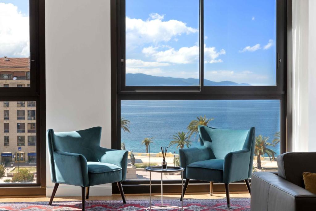 a living room with two chairs and a view of the ocean at Grand T3 de Standing Hyper Centre 150 m plage in Ajaccio