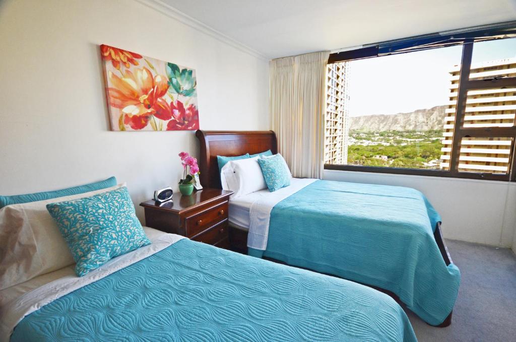 Cette chambre comprend 2 lits et une fenêtre. dans l'établissement Waikiki Banyan 1909 Amazing Views and Just Steps to the Beach, à Honolulu