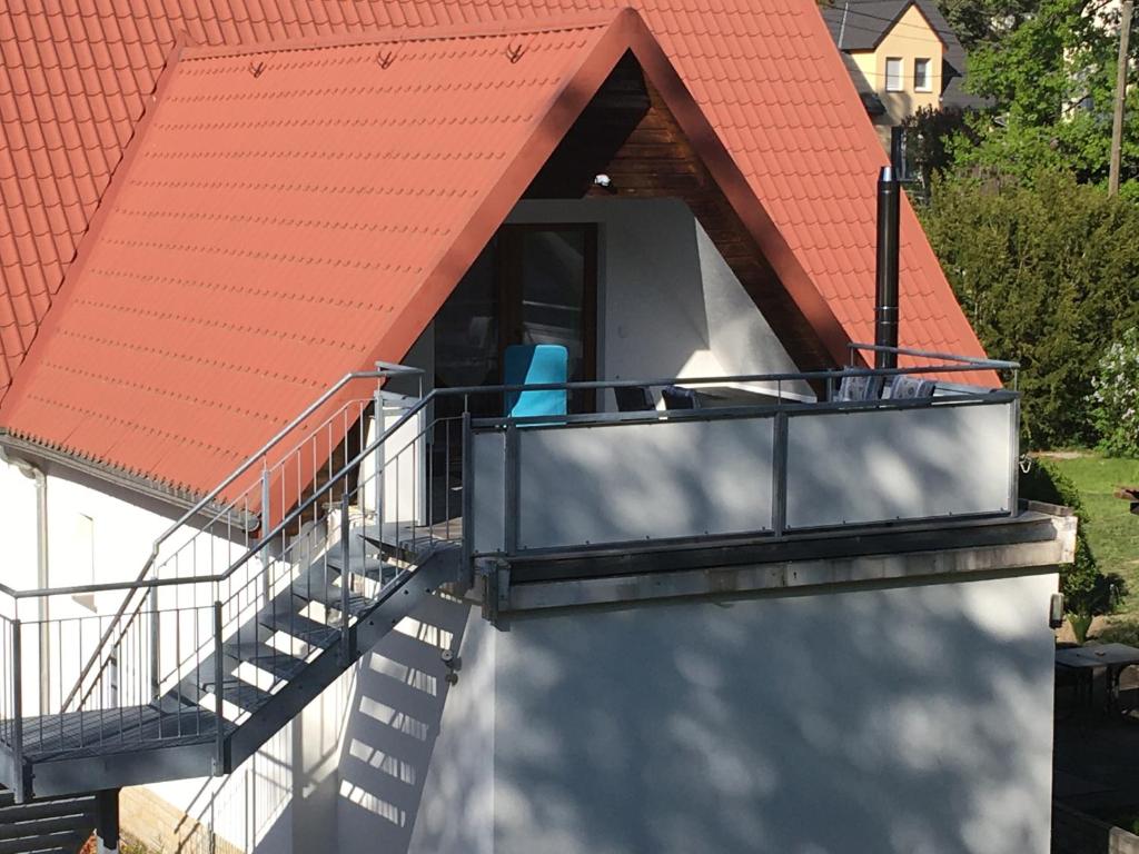 a house with a balcony with a roof at Ferienwohnung Möckel in Struppen