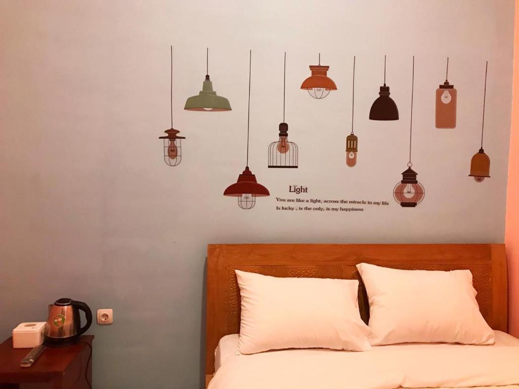 RoomZ Budget Residence في سيمارانغ: غرفة نوم بها سرير مع العديد من الأضواء فوقها