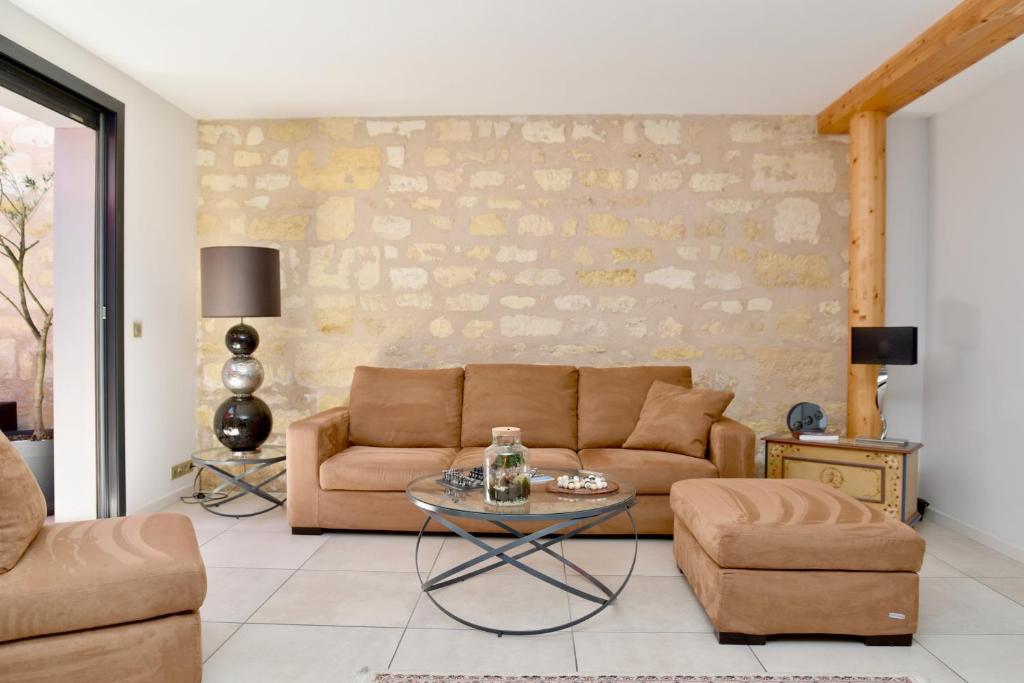 a living room with a couch and a table at Chambres à Bord'O in Bordeaux