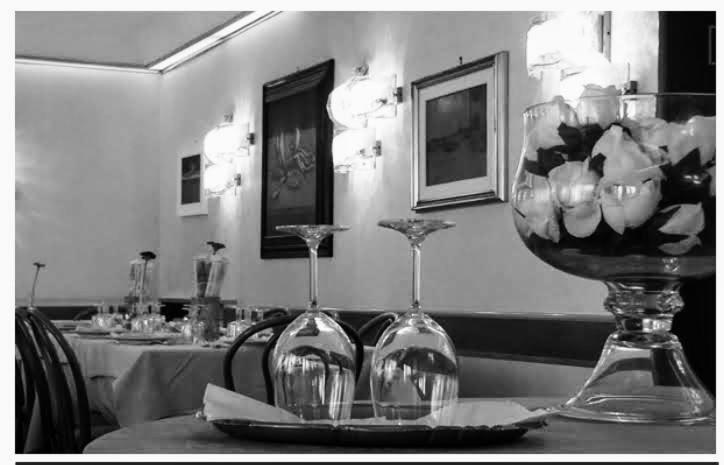a table with two wine glasses on a table at Hotel Belvedere in Venice-Lido