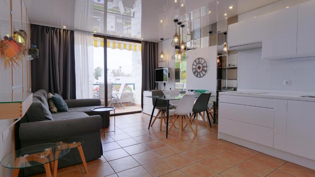 プラヤ・デ・ラス・アメリカスにあるBeach Life 365 Apartmentのキッチン、リビングルーム(ソファ、テーブル付)