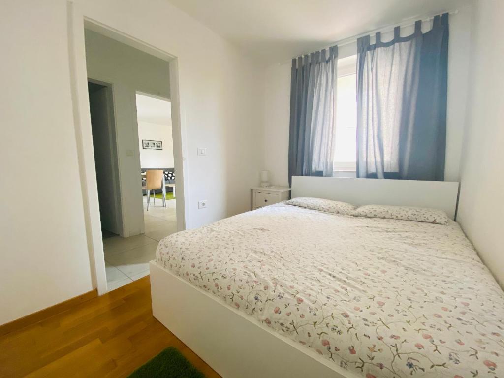 een witte slaapkamer met een bed en een spiegel bij Apartments Lucija in Portorož
