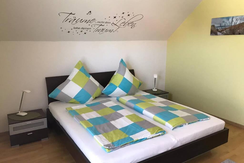 1 dormitorio con 1 cama con almohadas coloridas en Ferienwohnung „Anhaide“ en Wörth am Rhein