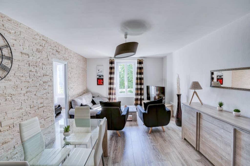 ein Wohnzimmer mit Ziegelwand in der Unterkunft Appartement T3 classé***centre ville in Périgueux