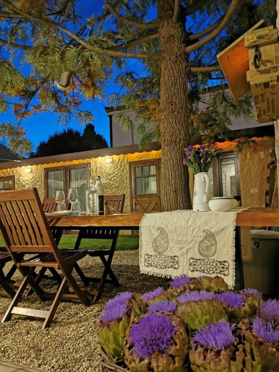 a patio with a table and chairs and flowers at ZEVKLİLER ALAÇATI hotel in Alaçatı