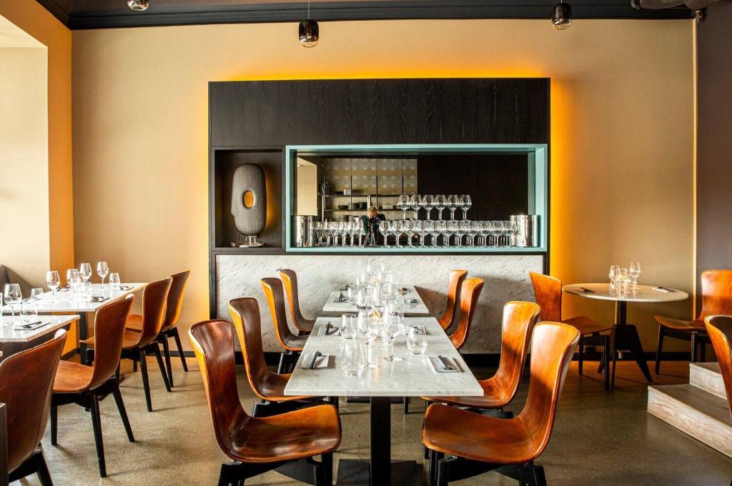 a dining room with tables and chairs and a mirror at Wex Hotels in Fredrikstad