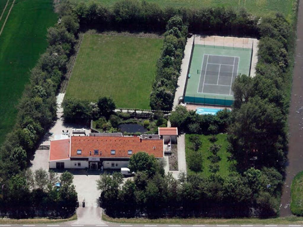 een luchtzicht op een huis met een tennisbaan bij B&B Plompetorenzicht in Burgh Haamstede