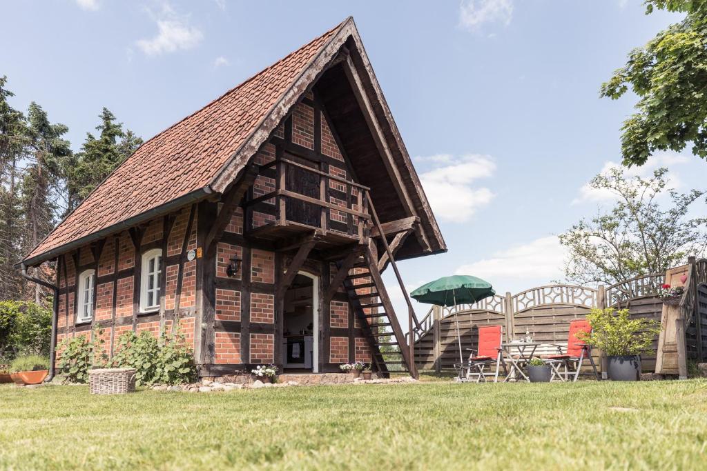 a small house with a gambrel roof and a porch at Fachwerk-Treppenspeicher, Ruhe auf dem Land, Haustiere willkommen, Leihfahrräder, 24-7 check in in Kirchlinteln